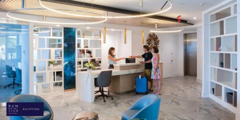 The image shows a modern, stylish lobby at the Rum Point Club Resort