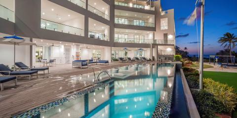 This image displays a luxurious beachfront resort complex, captured during the evening