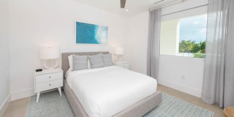 The image displays a bright, airy bedroom with a modern design aesthetic