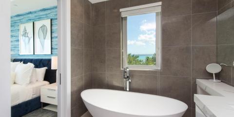 The image shows a modern bathroom with a view of a beach through a window
