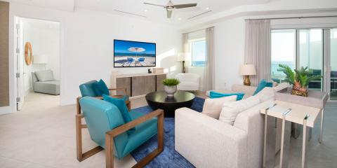 The image shows a modern, brightly-lit living room with coastal-themed decor