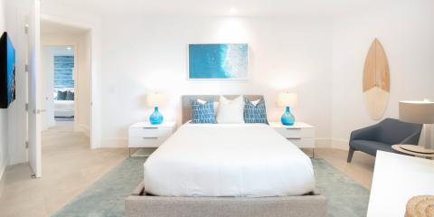 This image depicts a modern, brightly-lit bedroom with a beach theme
