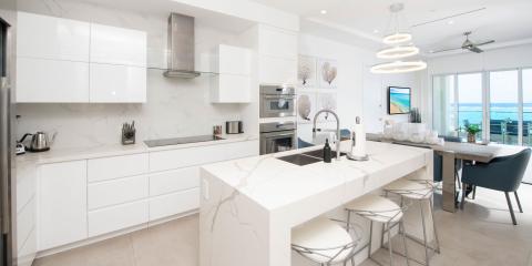 This image features a modern and luxurious kitchen with a clear ocean view