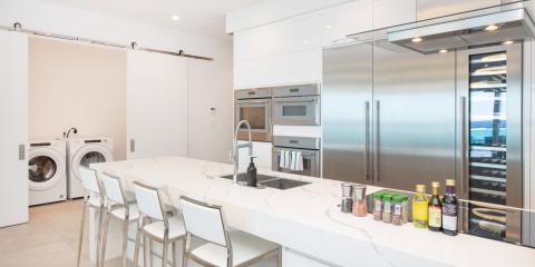 This image features a modern, well-equipped kitchen with a unique arrangement that includes laundry facilities