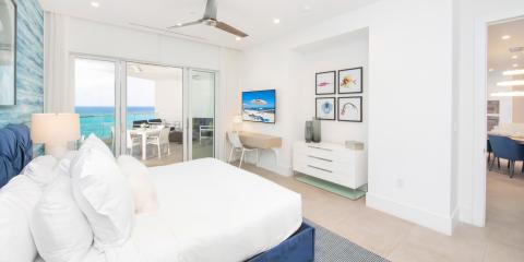This image shows a modern and luxurious bedroom with a coastal view