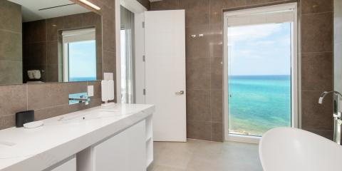 This image shows a modern bathroom with a stunning ocean view