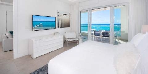 This image shows a modern, beachfront bedroom
