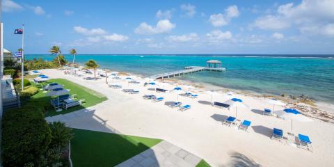 This image shows a picturesque beach resort with a pristine sandy beach and a vibrant blue sea