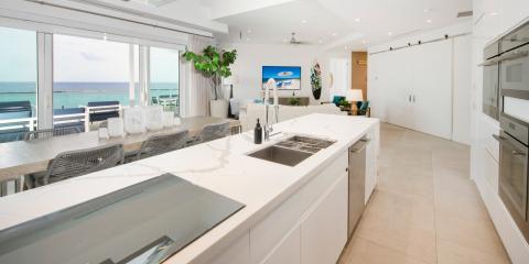 This image showcases a luxurious, modern kitchen with an impressive ocean view