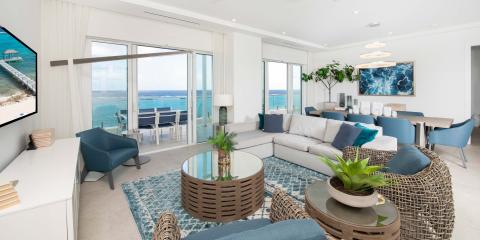 This image shows a modern, stylish living room with a stunning ocean view