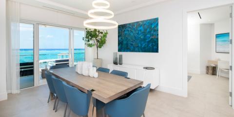 This image shows a modern, bright dining area with a coastal view