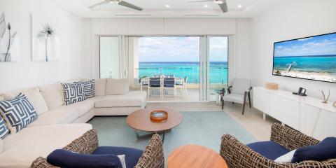 This image shows a view from a beautifully decorated living room overlooking a beach