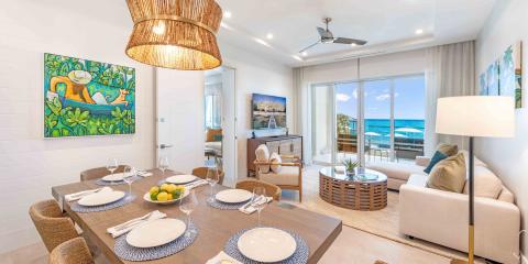 This image shows a beautifully decorated beachfront dining and living room in a modern house