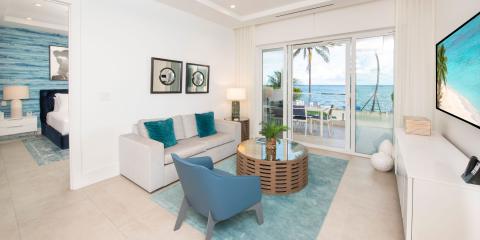 The image shows a beautifully arranged modern living room with a beachside view