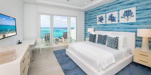 The image shows a luxuriously appointed beachfront bedroom