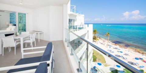 The image shows a modern and luxurious oceanfront balcony view from an apartment or hotel