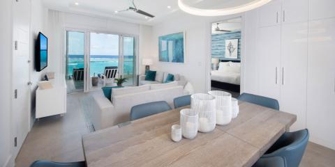 The image shows a modern, beachfront living space with a sleek design