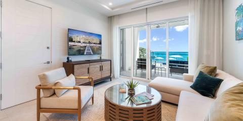 The image shows a modern living room with a beachfront view