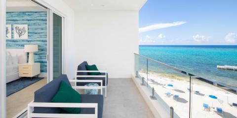 This image depicts a beachfront balcony of a modern hotel or apartment