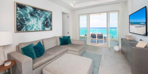 This image depicts a modern beachfront living room with an excellent view of the ocean