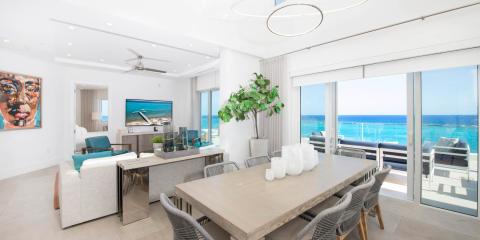 This image depicts a modern, luxurious living space with a picturesque ocean view