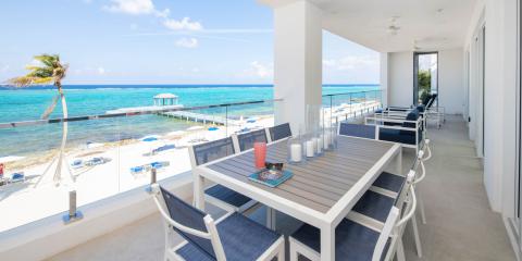 This image features a balcony of a beachside property with a beautiful view of the ocean