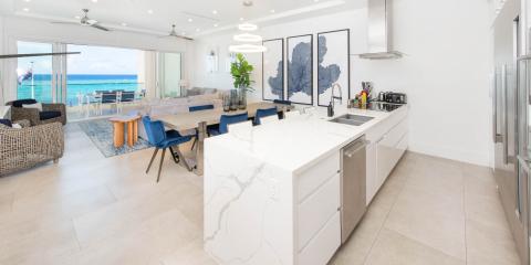 This image features a modern and spacious open-plan living area that includes a kitchen, dining space, and lounge area