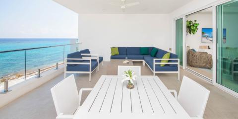 This image features a modern and stylish outdoor balcony overlooking a breathtaking ocean view