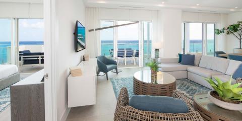 This image features a modern, oceanfront living room with a bright and airy design