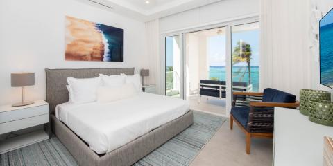 This image features a stylish, modern bedroom that is designed with a fresh and airy atmosphere