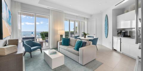 This image showcases a modern, well-lit beachfront living space that seamlessly blends the inside with the stunning outdoor view