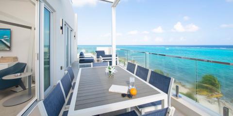 This image showcases an oceanfront balcony with a stunning view of a bright blue sea