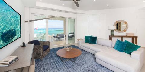 This image shows a modern beachfront living room with an open design that seamlessly blends with the beautiful outdoor landscape
