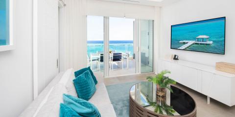 This image shows a modern, luxurious interior setting with a stunning beach view