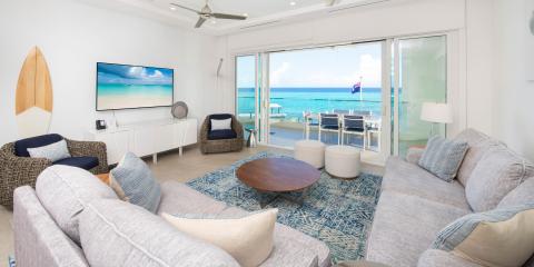 This image shows a modern, well-decorated living room with a coastal theme