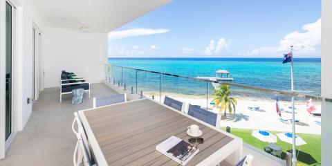 This image shows a serene beachfront balcony view from a modern building