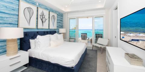 This image shows an elegantly decorated bedroom in a beachfront setting