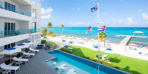 The image depicts a luxurious beachfront hotel or resort
