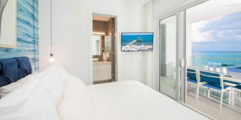 The image features a well-furnished modern bedroom suite with a sleek and contemporary design