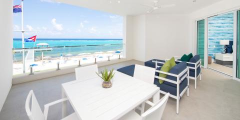 The image shows a modern and well-lit beachfront patio area within a residential or hotel setting