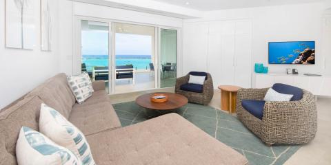 This image shows a modern and stylish living room with a beautiful view of the beach
