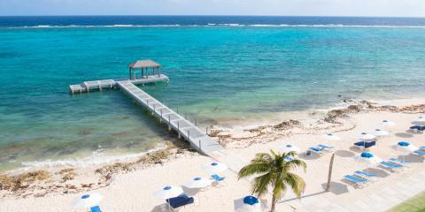 This image features a beautiful beach scene with a wooden jetty extending into vibrant turquoise waters