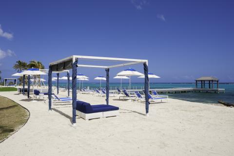 The image shows a scenic beach setting with luxury amenities