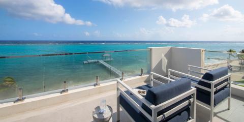 This image shows a luxurious outdoor terrace overlooking a stunning seascape