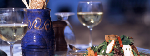 This image features a dining arrangement, likely set outdoors given the natural lighting and blurred background that suggests a spacious environment
