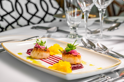 This image shows a beautifully presented dish featuring two seared scallops