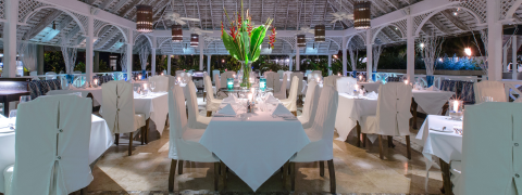 This image shows a beautifully arranged outdoor dining area at nighttime, likely part of a restaurant