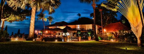 This image captures a picturesque evening scene at a tropical resort or restaurant