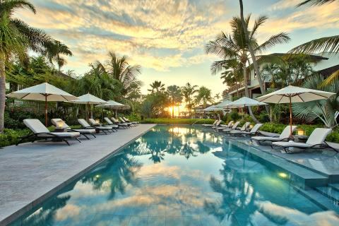 The image shows a beautiful and relaxing luxury resort setting during sunset