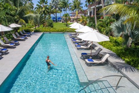 This image shows a sophisticated outdoor pool area at a luxurious resort